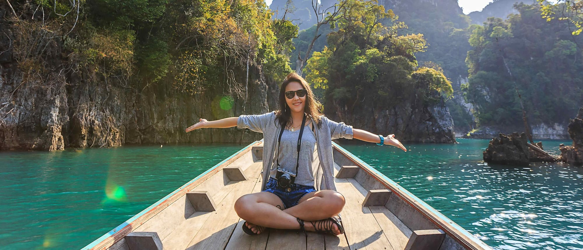 seorang wanita sedang menikmati waktu liburannya di atas perahu di perairan yang ia kunjungi.